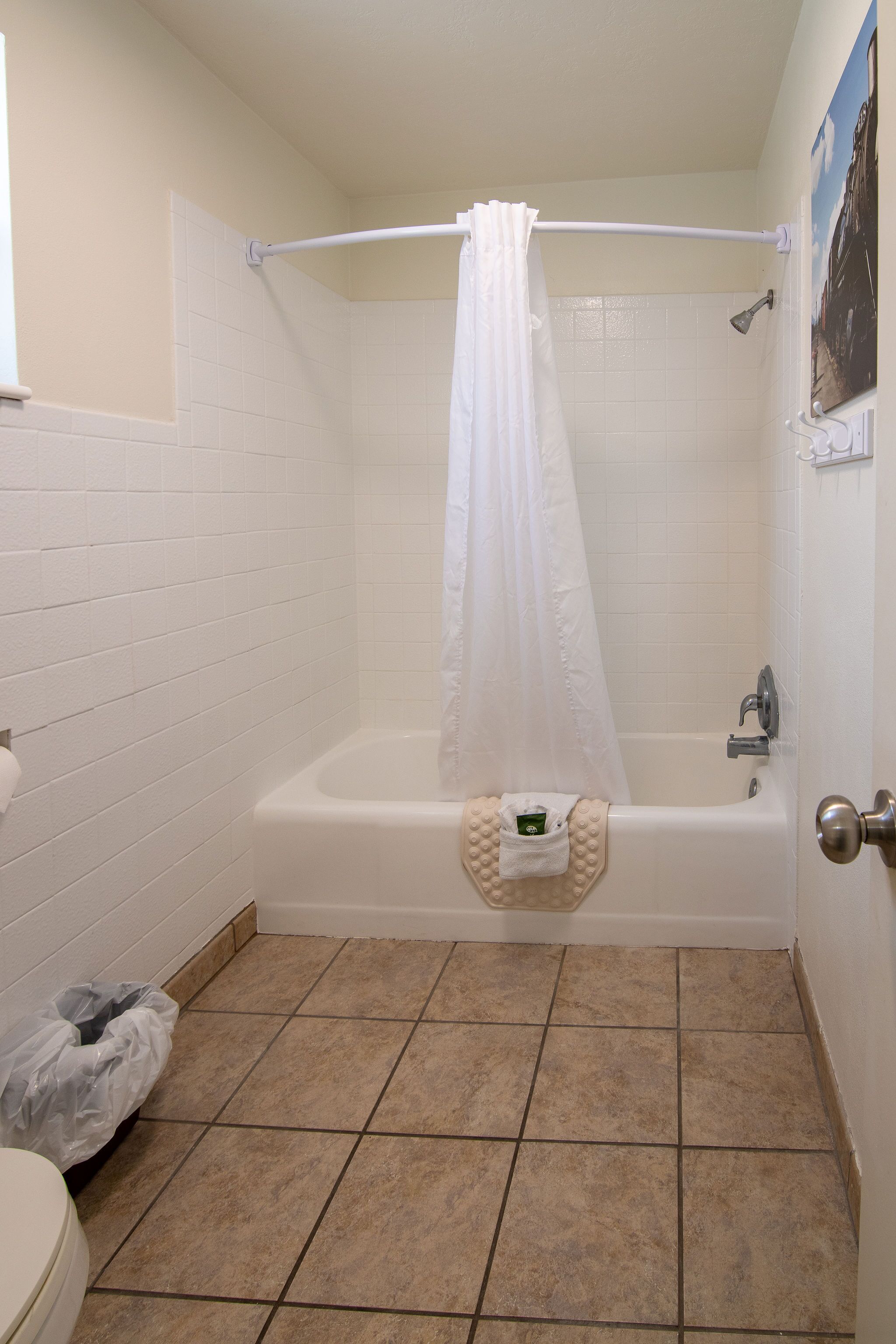 Ein Badezimmer mit Badewanne, Duschvorhang und Handtuchhalter.