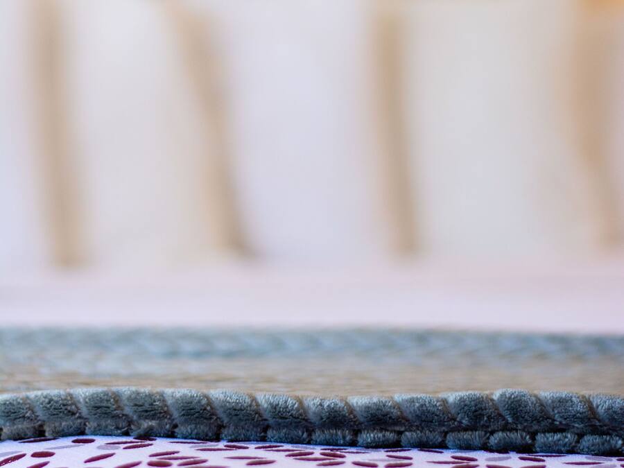A close-up of a patterned carpet with a textured edge.