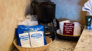 A coffee maker, a basket with some items, and a sign with text.