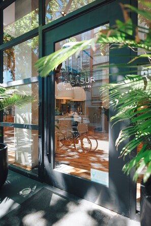 A hotel entrance with a glass door, a bicycle parked inside, and a sign reading 'CASASUR PALERNO HOTEL'. - CasaSur Palermo Hotel (Buenos Aires)
