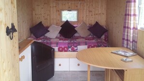 A cozy room with a bed, a small table, and a window. - Shepherds Lodge (Worcester)
