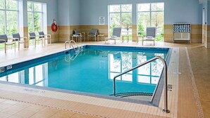 Una piscina con bordo piastrellato, sdraio e una postazione per il bagnino.