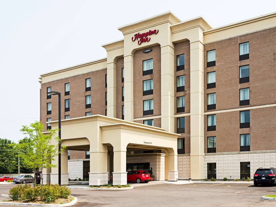 Ein Hampton Inn Hotel mit Ziegel Fassade, mehreren Stockwerken und einem überdachten Eingang.