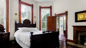 A traditional bedroom with a four-poster bed, wooden flooring, and a fireplace. - Brava House Bed and Breakfast (Austin)