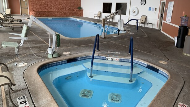 A swimming pool with a 30 ft depth limit sign, a brick wall, and a water fountain. - Longhollow Point Inn Studio 1105 (Galena)