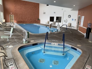 Ein Schwimmbecken mit einem tiefenlimit-Schild für 30 Fuß, einer Backsteinmauer und einer Springbrunnen.