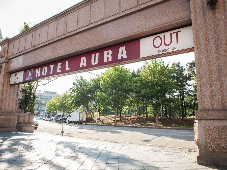 A hotel entrance with a sign reading "HOTEL AURA OUT".