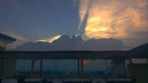 Een terras op het dak met uitzicht op de stadshemel bij zonsondergang.