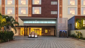 Een hotel met een moderne gevel, een opvallend Days Hotel bord en een goed verlichte entree met een verharde oprit.