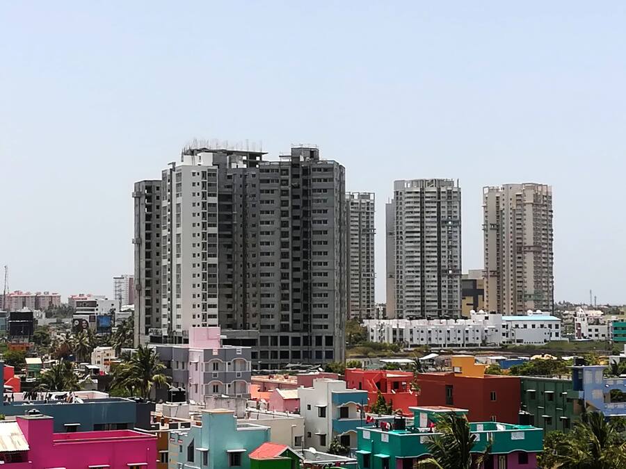 A cityscape with high-rise buildings and colorful residential structures.