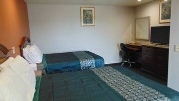 Habitación de hotel con dos camas, un escritorio, una silla, un aparador y una televisión.