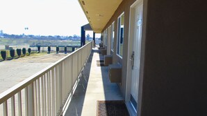 A hotel balcony with a view of a golf course. - Corcoran Country Inn (Corcoran)