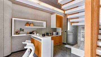 A modern kitchen with white cabinetry, a built-in microwave, and a glass door refrigerator.