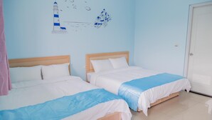 Habitación de hotel con dos camas, pared de azul claro y un diseño sencillo y limpio.