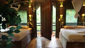 A room with two beds, wooden flooring, and large windows with curtains. - Khao Sok Tree House (Phanom)