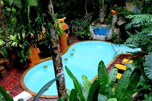 Alberca al aire libre y camastros 