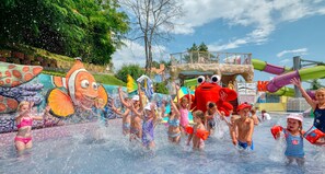 Un parc aquatique doté de diverses attractions aquatiques et d’un grand crabe gonflable servant de mascotte.