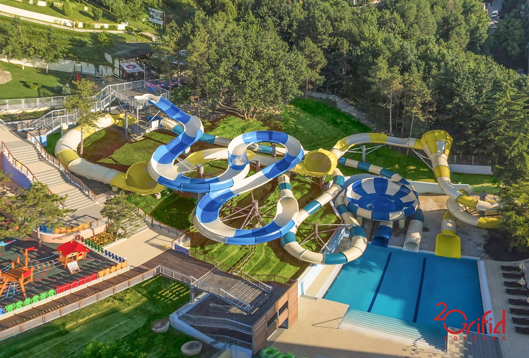 An aerial view of a water park with multiple water slides and a swimming pool.