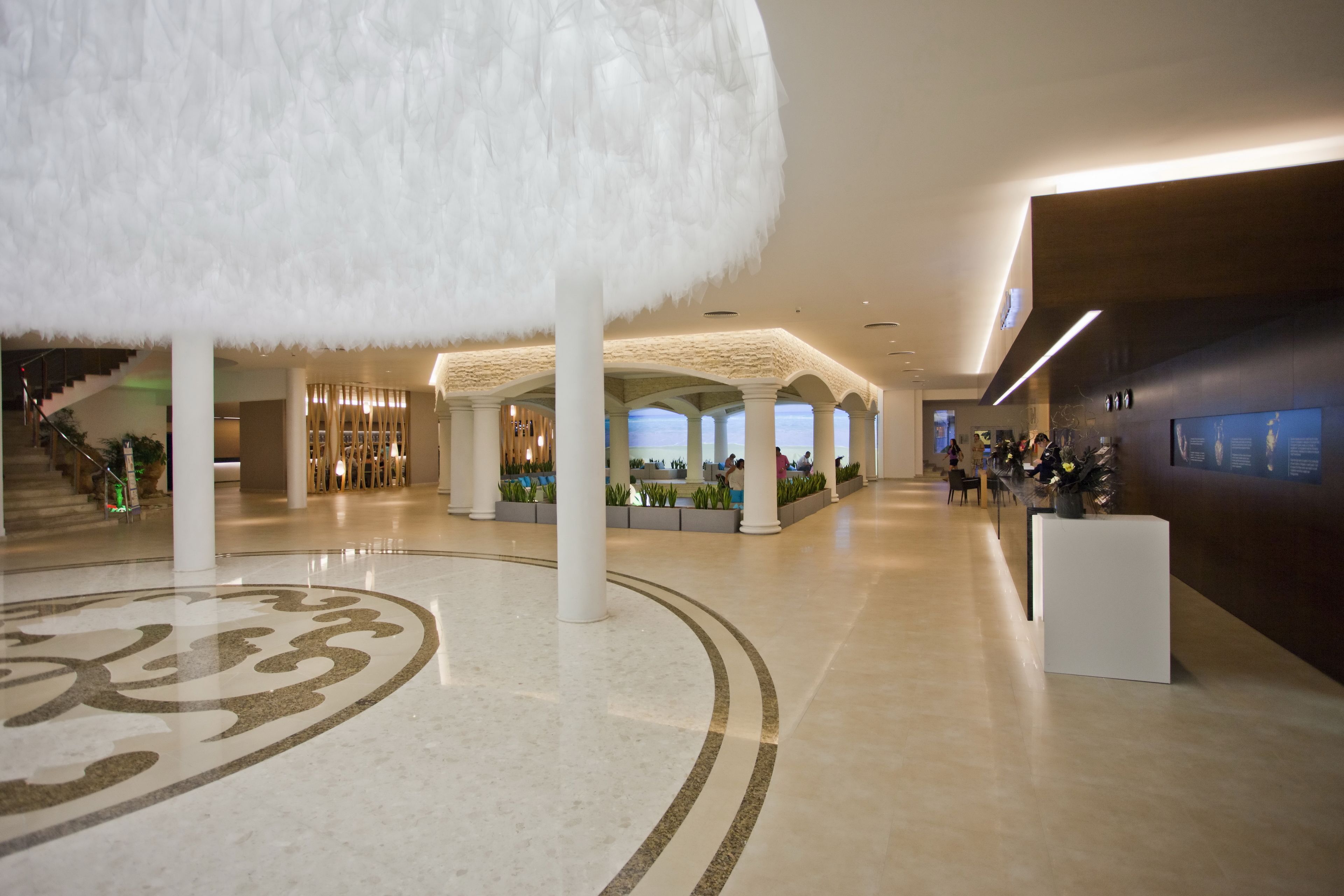 A spacious lobby with a high ceiling, a central column, and a decorative floor pattern.