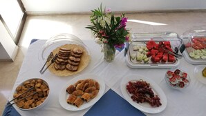 A buffet table with various food items including pastries, fruits, and cookies. - Aegeon Hotel (Kos)