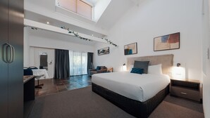 A modern hotel room with a large bed, a desk, a chair, and a balcony with a view. - The Select Inn Gosford (Wyoming)