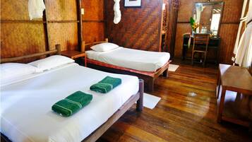 A room with two wooden beds, a wooden chair, and a wooden desk.