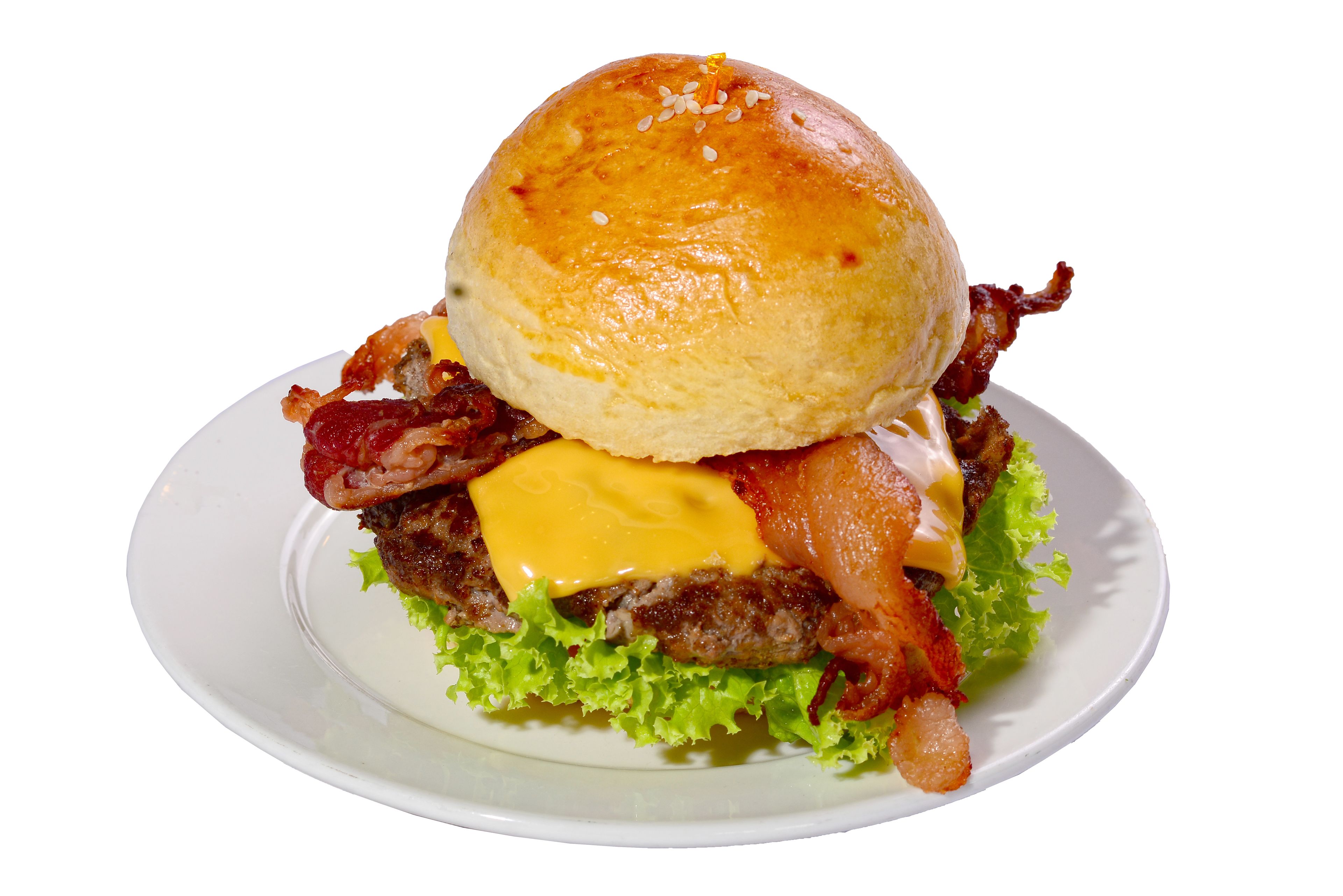 A burger with lettuce, cheese, bacon, and a bun on a plate.