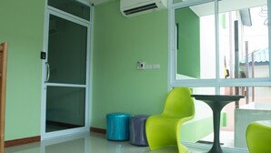 Une pièce dotée d’une porte-fenêtre coulissante, d’une fenêtre offrant une vue agréable, d’une table et de deux chaises.
