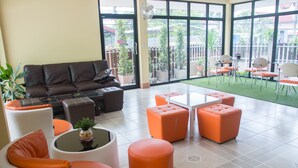 Un espace de détente moderne comprenant un canapé, des poufs et une table basse.