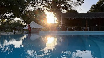 Una piscina al aire libre, sillones reclinables de piscina