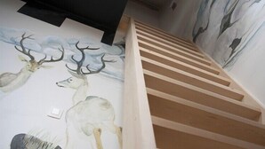 Una escalera con escalones de madera y un mural de ciervos en la pared.