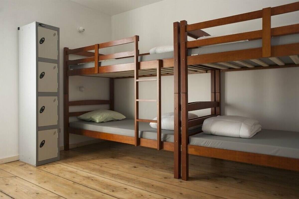 Dormitorio con literas, armario y suelo de madera.