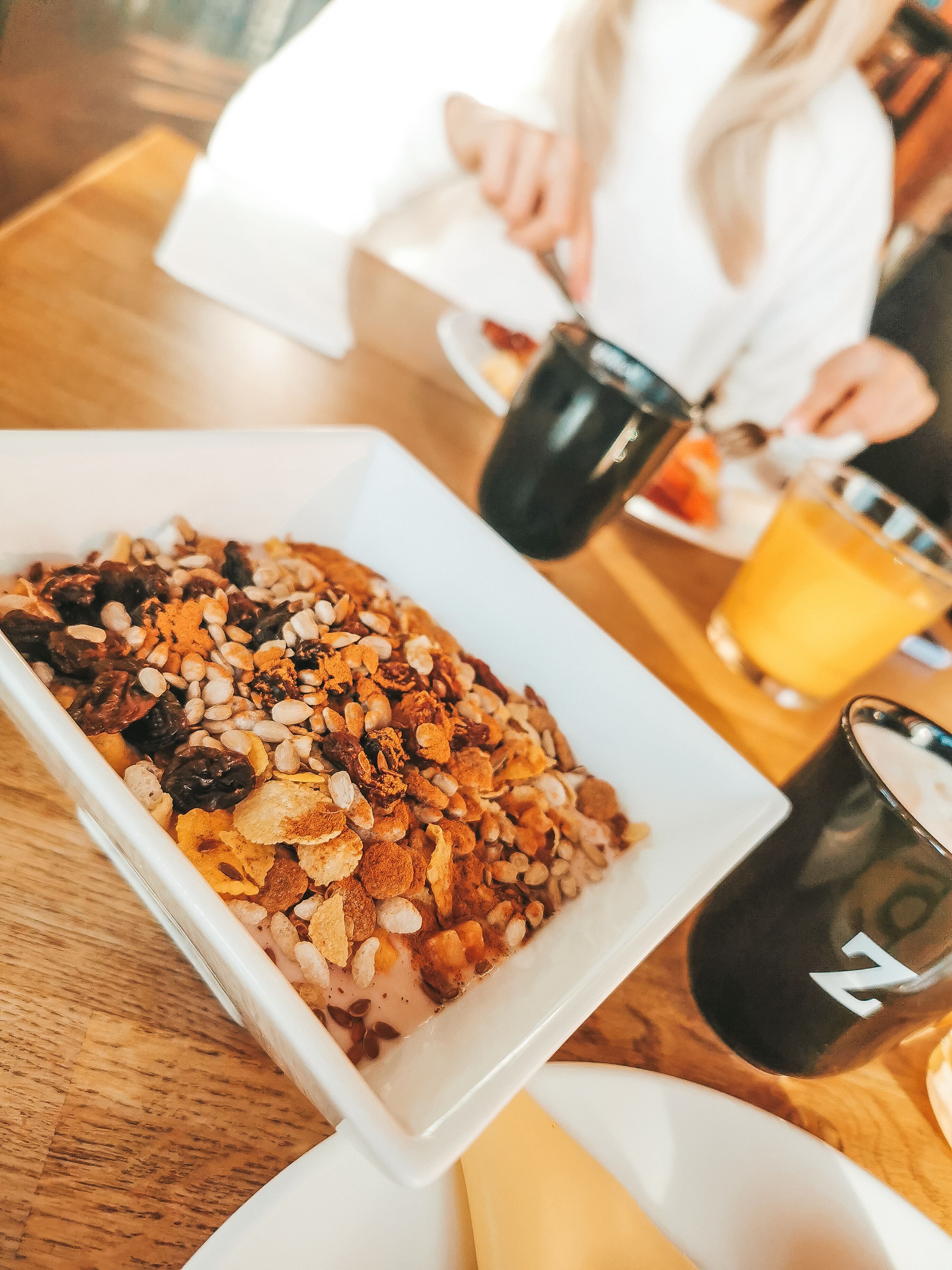 Une table mise pour le petit-déjeuner, avec une assiette de céréales et une tasse.