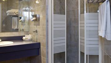 Une salle de bain moderne avec une douche à parois de verre, un meuble-lavabo avec un miroir et un porte-serviettes.