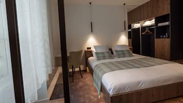 A bedroom with a bed, bedside tables, a chair, and a wardrobe.