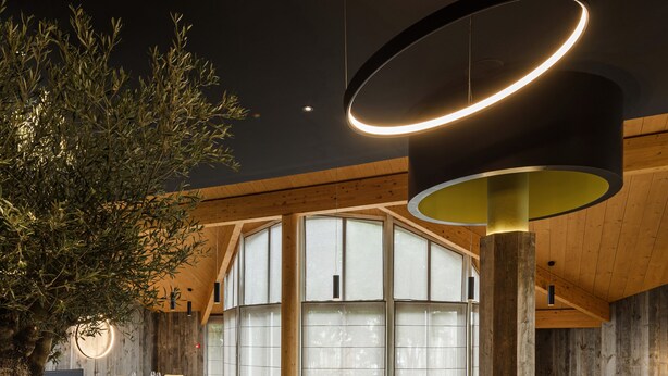 A spacious dining area with multiple tables and chairs, large windows, and a modern ceiling light fixture. - Logis Hôtel Restaurant Spa Parenthèse (Chille)