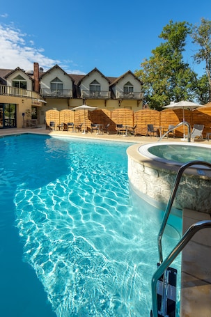 Una piscina al aire libre de temporada, sombrillas. Logis Hôtel Restaurant Spa Parenthèse