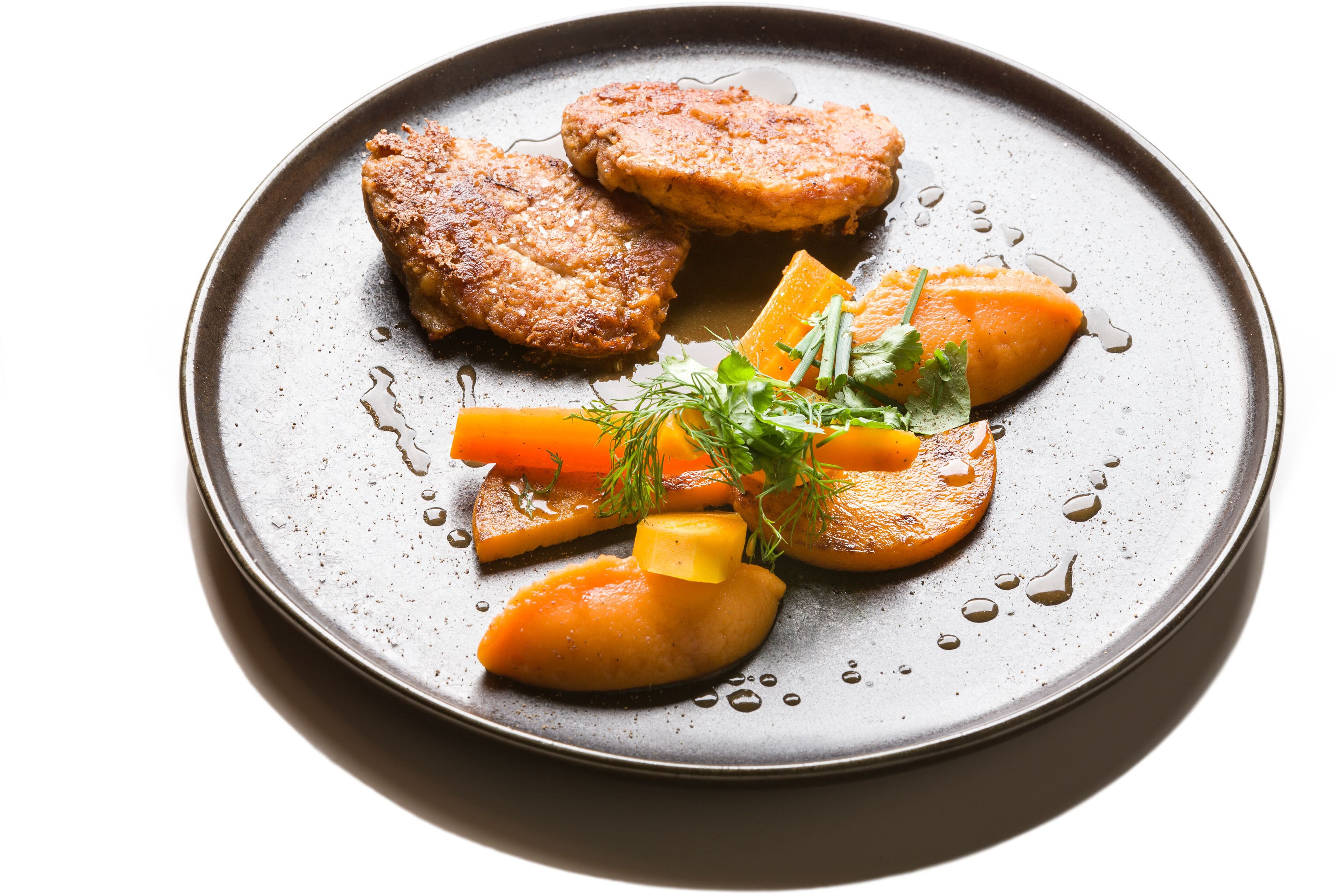 Un plato con alimentos, incluyendo hamburguesas, zanahorias y una guarnición.