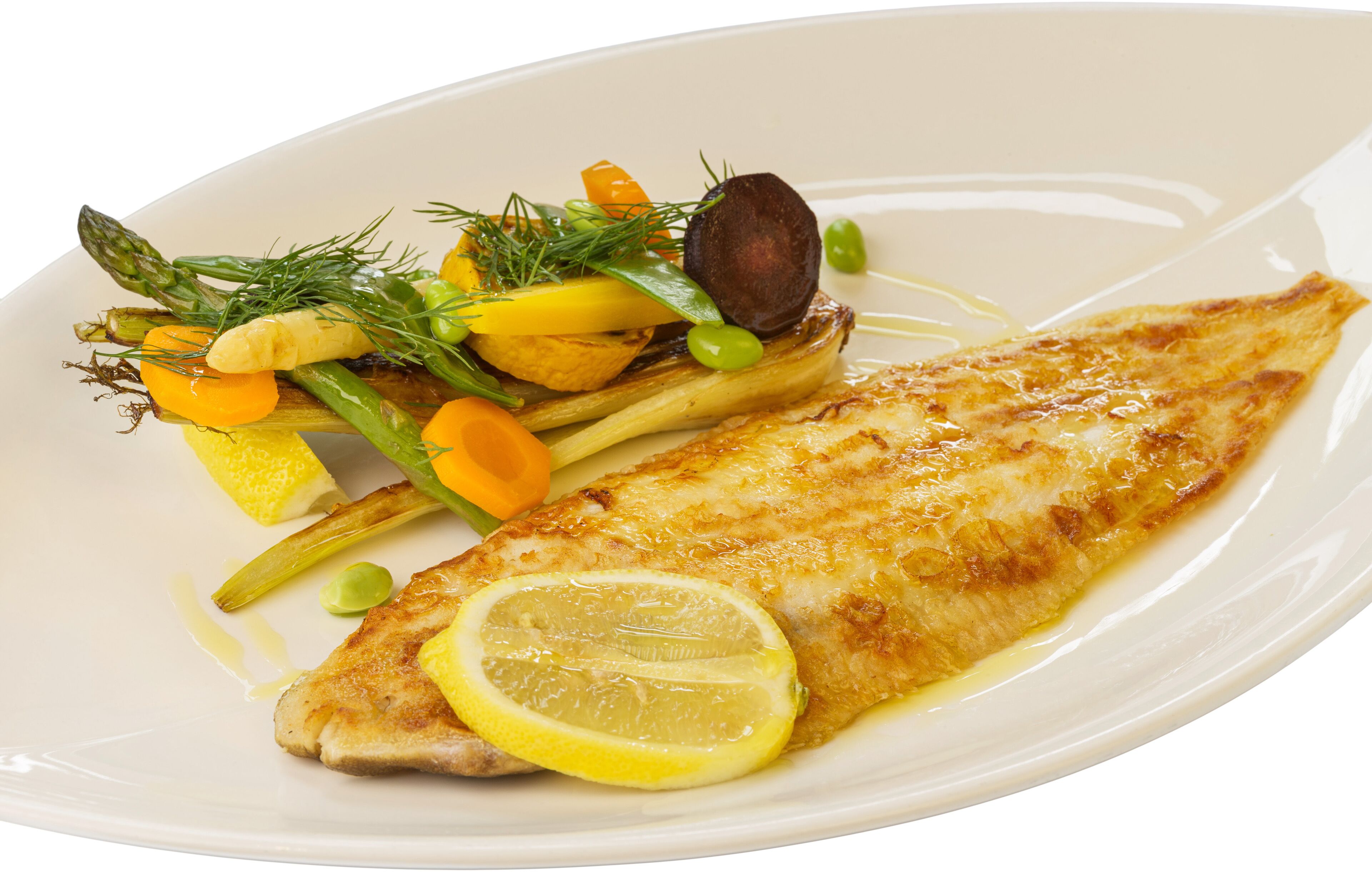 A white plate with a grilled fish fillet, lemon slice, and a side of vegetables including asparagus, carrots, and green beans.