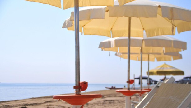 Beach umbrellas and lounge chairs on a sandy beach. - Hotel Sette Note (Silvi)