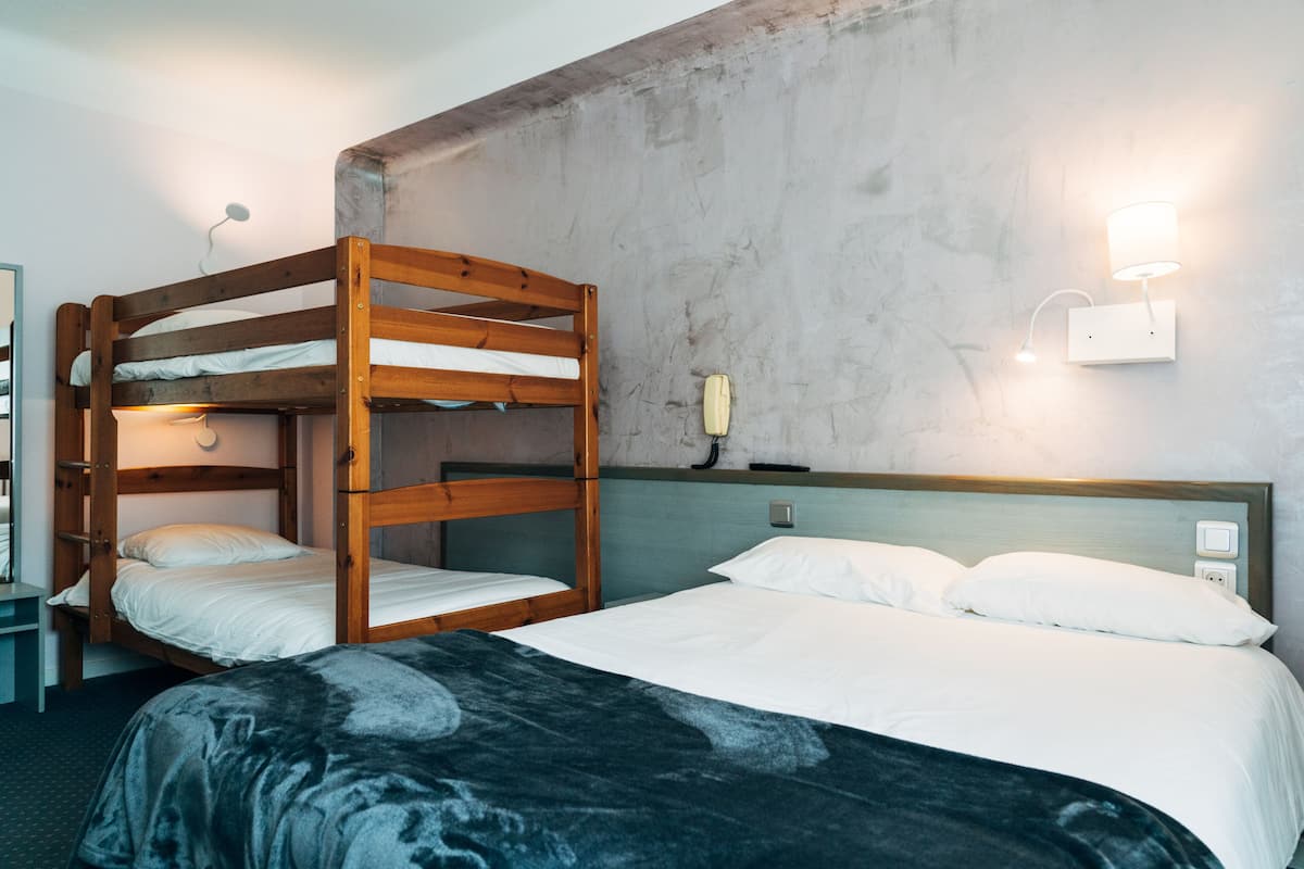 Ein Schlafraum mit Etagenbett, einem Nachttisch und einer Wandleuchte.