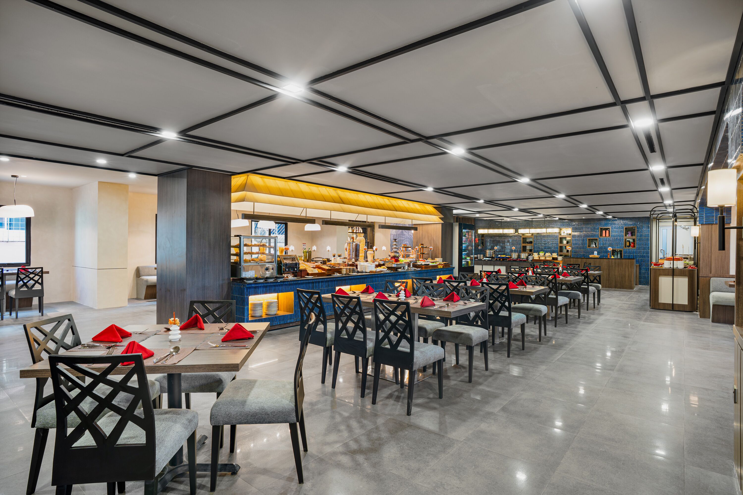 Un restaurant moderne doté d’un bar central, de nombreuses tables et de chaises.