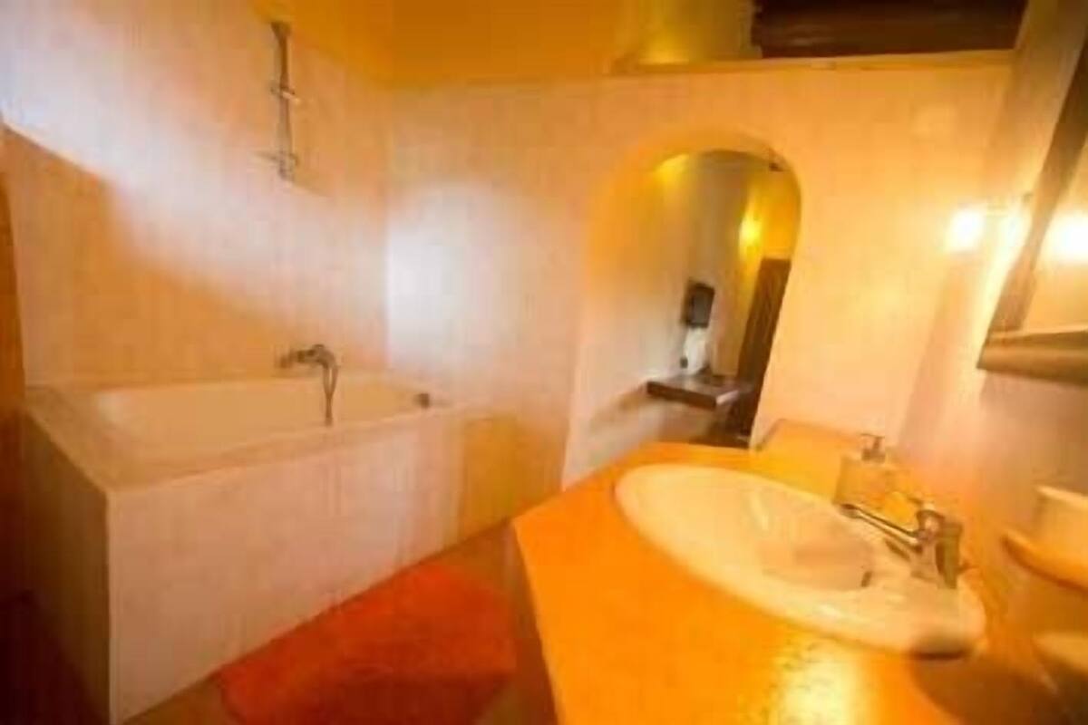 A bathroom with a bathtub, sink, and mirror.