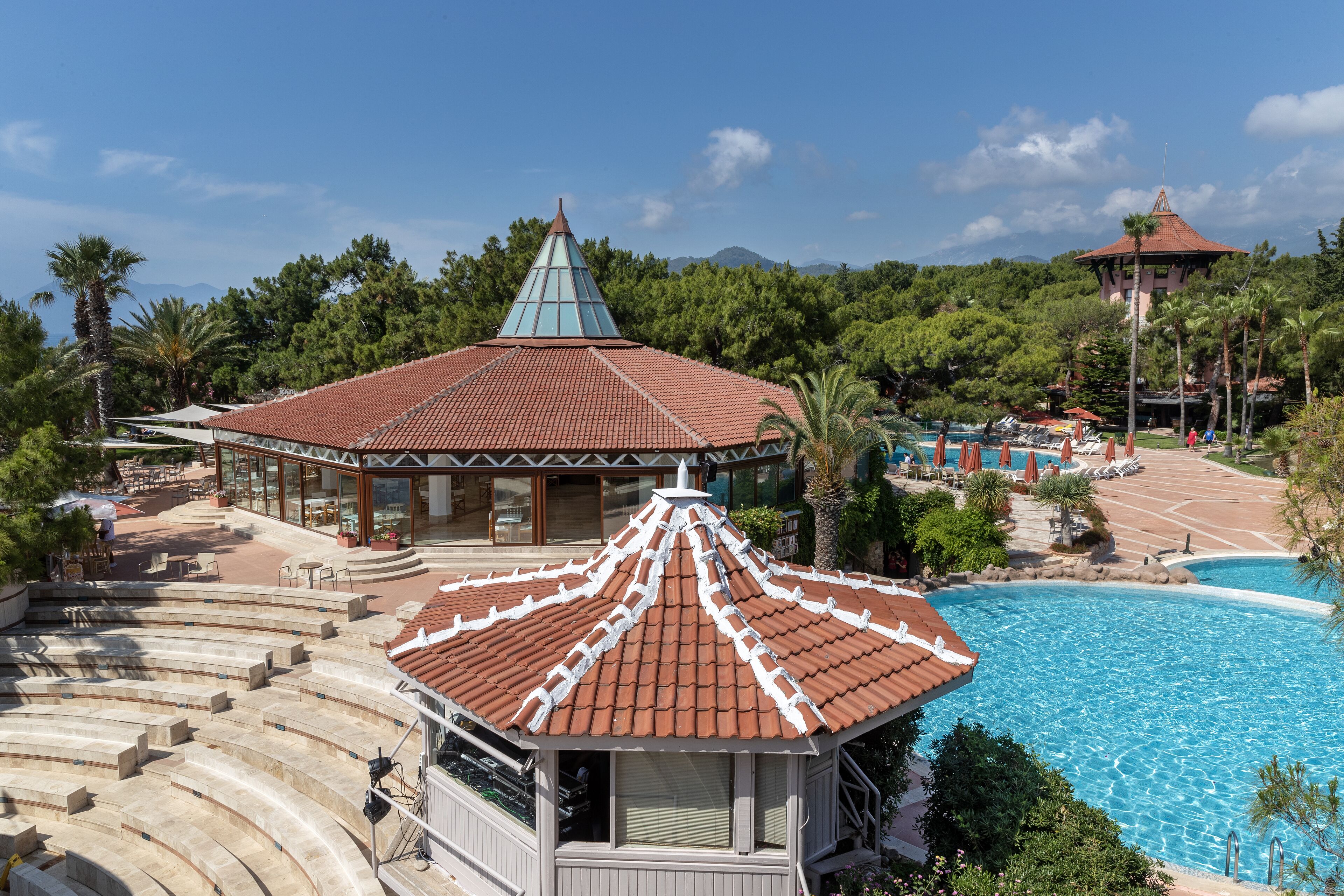 Un resort con piscina, un espacio de estar techado al aire libre y vistas a las montañas.