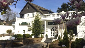 En vit byggnad med en balkong och en skylt med texten ”Hotel Ramor-Garni”.