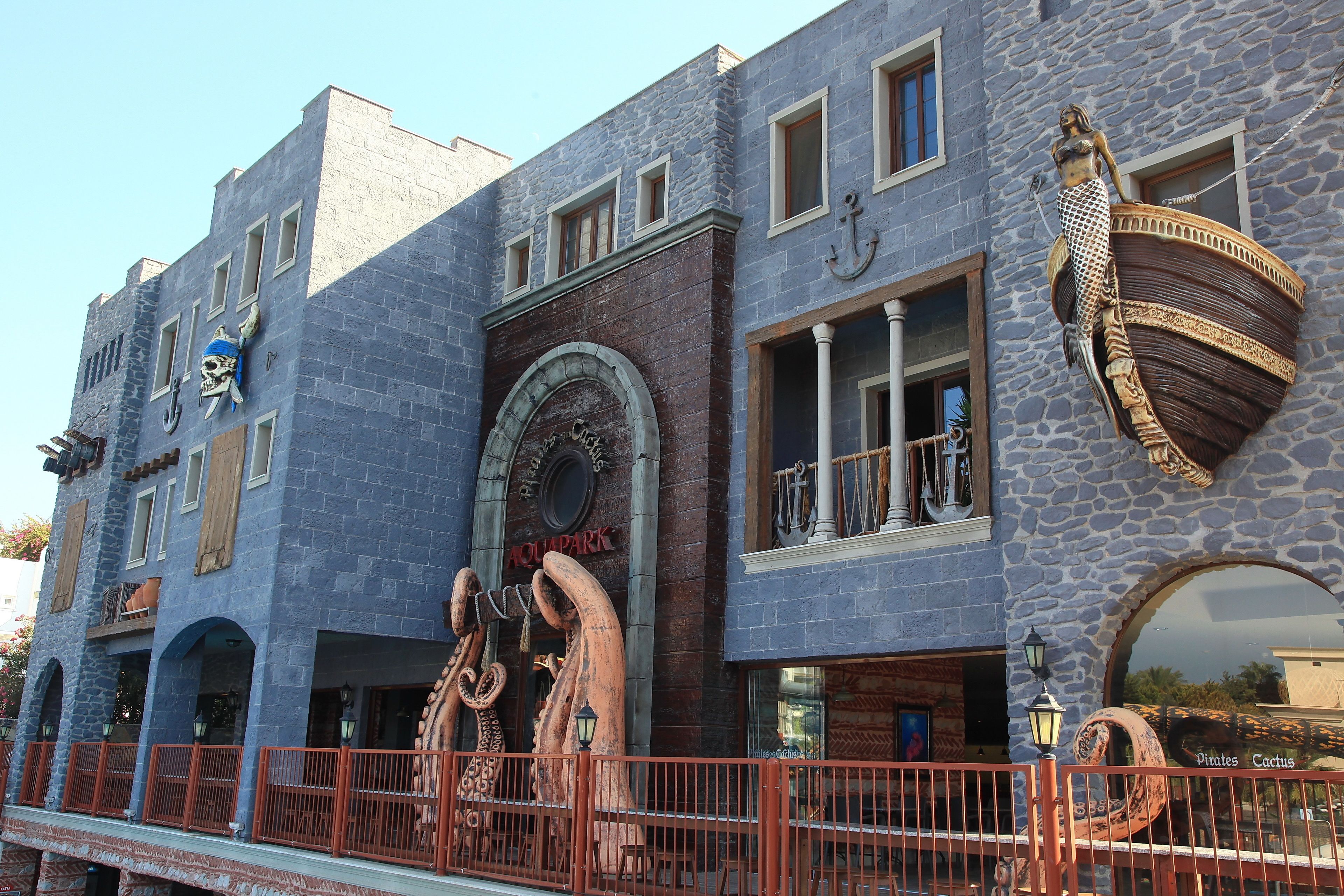 A building with a stone facade, arched windows, and a sign that reads "Aquarium."