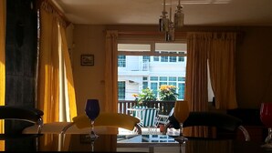 A dining area with a view of a balcony and building.