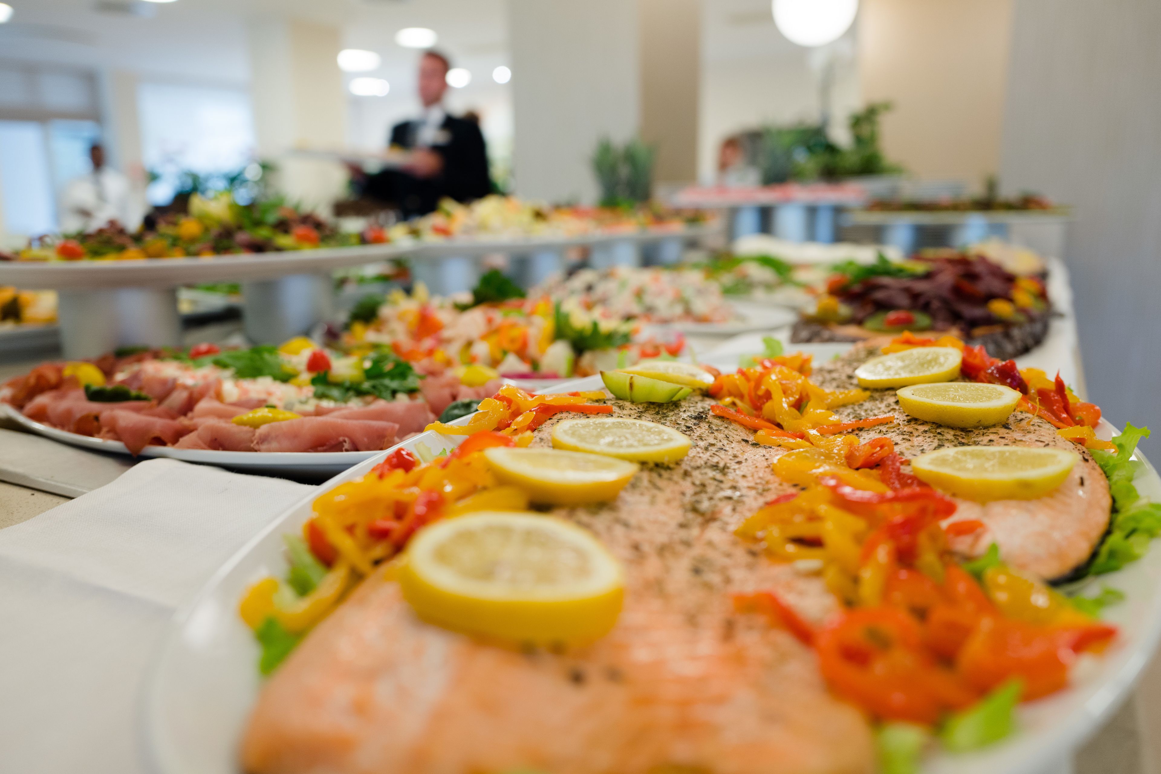 Ein reichhaltiges Buffet mit verschiedenen Speisen, darunter Lachs, Gemüse und Fleisch.