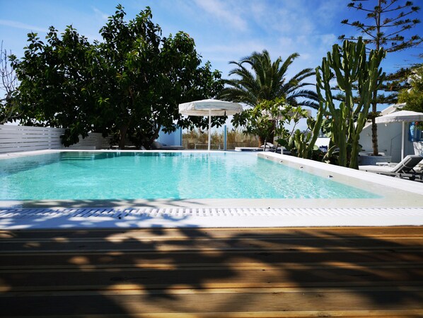 A swimming pool with lounge chairs and a pergola. - La Stella Stay (Mykonos)