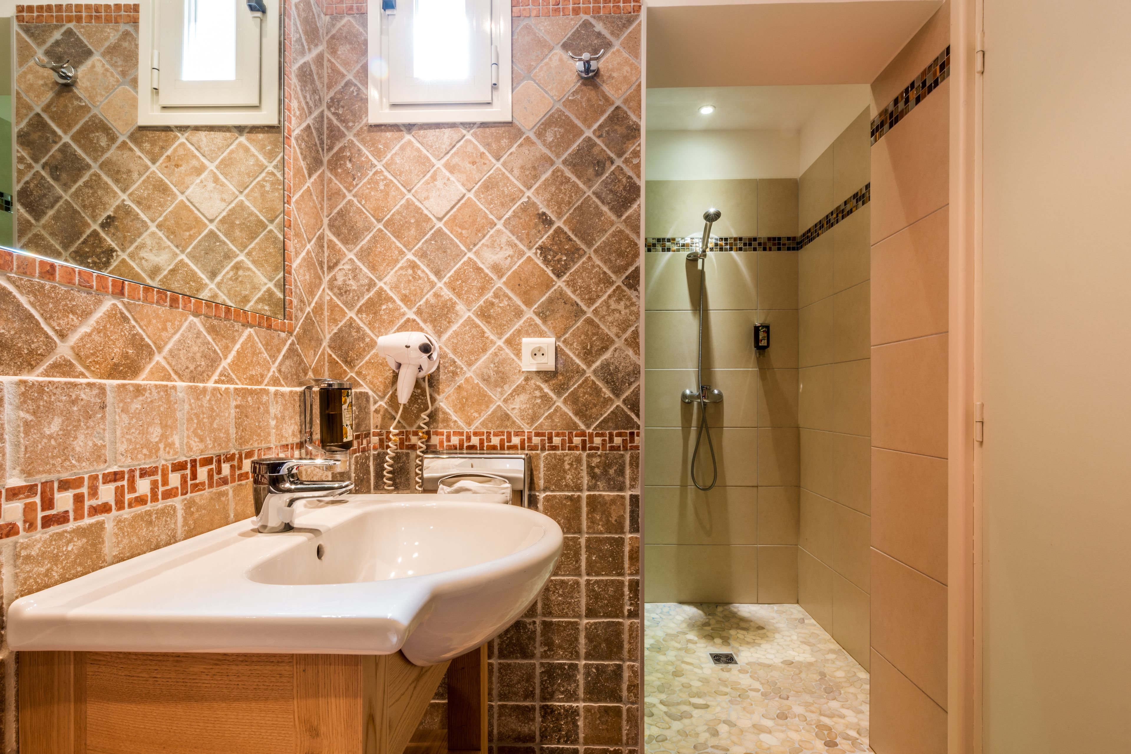 Un baño con lavamanos, espejo y ducha.